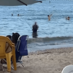 [VÍDEO] Perigo: homem é visto pescando com vara e anzol em meio aos banhistas em praia de Penha