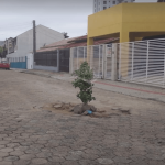 Buraco no meio de rua de Penha faz vizinhos deixarem alerta e reforçarem pedido de conserto