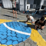 [VÍDEO] Em clima de Copa do Mundo, moradores de Penha pintam rua com as cores da bandeira do Brasil
